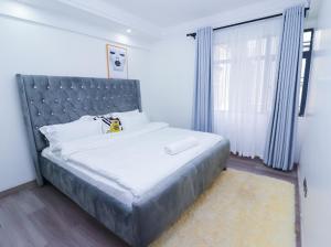 内罗毕Fabby homes的一间卧室配有一张大床和金属床头板