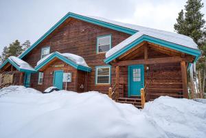 莱德维尔Giddy Betsy 3B的雪中带蓝色门的小木屋