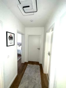 汉诺威Apartment Alana的拥有白色墙壁和白色天花板的走廊