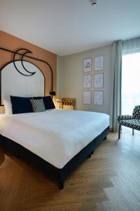 阿姆斯特尔芬Cityden Stadshart的卧室配有一张大白色床和窗户
