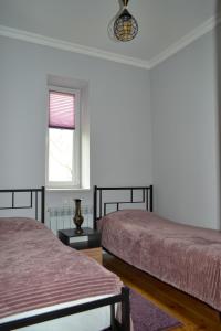 迪利然Sunny Lodge Dilijan的一间卧室设有两张床和窗户。