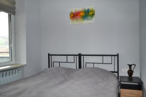 迪利然Sunny Lodge Dilijan的卧室配有一张床,墙上挂有绘画作品