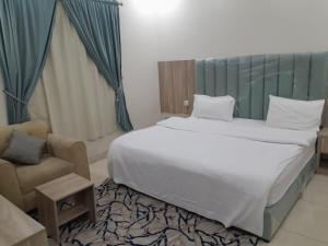 吉达دار الكيان للشقق المخدومة - Dar Al Kayan Serviced Apartments的一间卧室配有一张大床和一把椅子