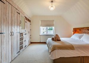 伯恩茅斯Throop House Cottage - Bournemouth的一间卧室设有一张大床和一个窗户。
