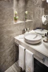 维也纳Hotel Zur Wiener Staatsoper的浴室设有白色水槽和镜子