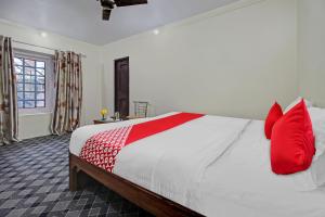 斯利那加Flagship Comfort By Comfay的一间卧室配有一张带红色枕头的大床
