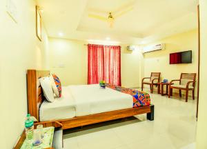 钦奈K HOTELS - CHENNAI AIRPORT的卧室配有一张床和一张桌子及椅子
