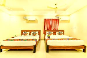 钦奈K HOTELS - CHENNAI AIRPORT的配有两张床的客房内。