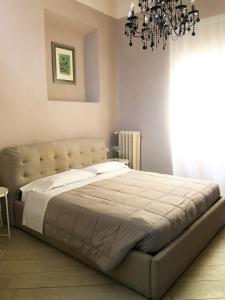 阿雷佐Allegra Toscana - Affittacamere Guest house的一间卧室配有一张带吊灯的大床