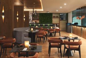 利马索尔The GrandResort - Limited Edition by Leonardo Hotels的一间带桌椅的餐厅和一间酒吧