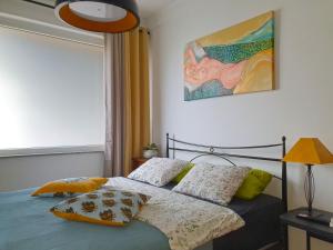 托尔明Apartment with Terrace Nona Pavla的卧室配有一张床,墙上挂有绘画作品