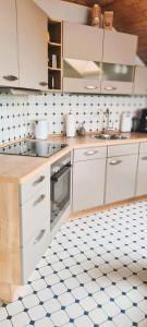 MüllenbachFerienwohnung Funk的厨房铺有蓝色和白色瓷砖地板,配有白色橱柜。