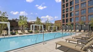 芝加哥3BR Elegant Glass Penthouse Pool With Deck & Gym的一座带椅子的大型游泳池和一座建筑
