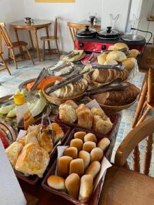 坎波斯杜若尔当Pousada Vila Tio Lé的一张桌子,上面摆放着各种面包和糕点