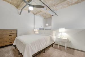 堪萨斯城2BR 2BA Spacious Historic Loft With Gym by ENVITAE的白色卧室设有一张大床和一个梳妆台
