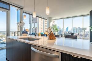 芝加哥3BR Luxury Glass Apartment With Views Pool & Gym的带水槽和大窗户的厨房