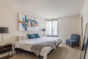 阿林顿2BR Executive Apartment with Balcony的一间卧室配有一张床和一张蓝色椅子