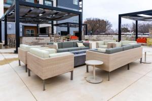 堪萨斯城2BR Luxury New Apartment with Outdoor Pool的天井设有几张沙发和椅子