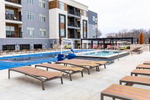 堪萨斯城2BR Luxury New Apartment with Outdoor Pool的大楼前带躺椅的游泳池