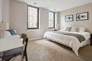 底特律2BR Downtown Luxury Getaway的卧室配有一张白色大床和一张书桌