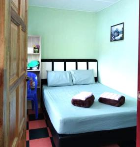 拉瑙D'TERRACE KUNDASANG的一间卧室配有一张带两个枕头的床