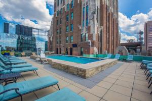 巴尔的摩2BR Distinguished Apartment Rooftop Deck & Gym的一座带椅子的建筑屋顶上的游泳池