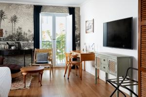 法鲁Casa Apollo Guesthouse的一间卧室配有桌子和一张书桌及电视
