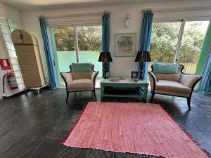 埃斯特角城Hotel Donatella mare boutique的客厅配有两把椅子和红色地毯