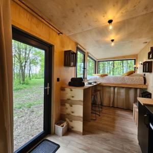 SonchampTiny House La Clairière au milieu des bois !的一间小房子,设有厨房和一张床