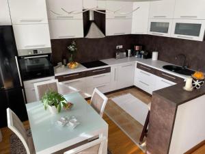 查查克Apartman Ares的厨房配有白色橱柜和桌椅