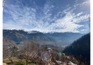 马拉里Zingo 1BHK Mudhouse的享有山脉和雪覆盖山脉的美景