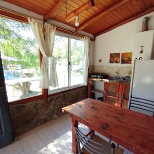 Piedras BlancasComplejo Cerro Norte的厨房配有木桌和大窗户。