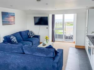 卡斯特Waves Guest Suites的客厅配有蓝色的沙发和电视