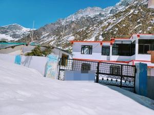 巴德里纳特Badrinath Guest House的一座有雪覆盖的山的建筑