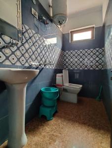 巴德里纳特Badrinath Guest House的蓝色的浴室设有水槽和卫生间