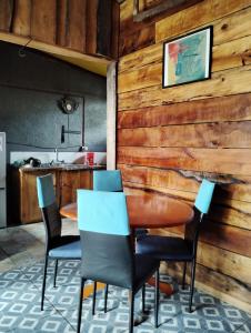 潘吉普伊hostal Coñaripe的用餐室设有木墙,配有桌椅