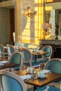 埃托日Le Château D'Etoges的一间带桌椅和吊灯的用餐室