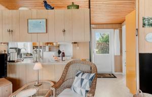 斯图伯克宾Awesome Home In Stubbekbing With 3 Bedrooms And Wifi的一间带柳条椅的客厅和一间厨房