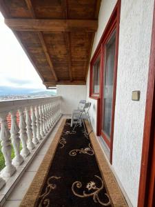 萨拉热窝Guesthouse Vratnik的阳台配有椅子和地毯。