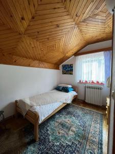 萨拉热窝Guesthouse Vratnik的一间卧室设有一张床和木制天花板