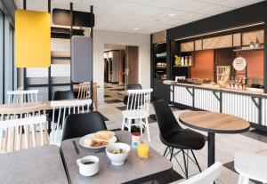 拉瓦勒B&B HOTEL Laval Ouest的一间带桌椅的餐厅和一间早餐室