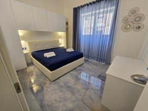 切萨雷奥港ALG Apartments con Parcheggio的一间卧室配有一张带蓝色床单的床和一扇窗户。