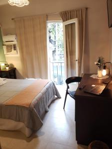 门多萨Hotel Namaste的一间卧室配有一张床、一张书桌和一个窗户。