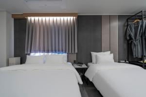 堤川市Number 25 Hotel Jecheon的带窗户的客房内的2张白色床