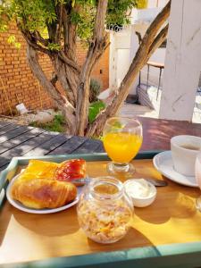 门多萨Hotel Namaste的一张桌子,上面放着一盘食物和一杯橙汁