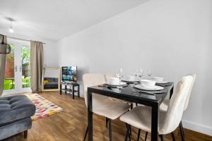 莱斯特Perfect house for large groups and families的一间用餐室,配有黑桌和白色椅子