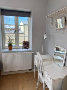 卢马Brohuspark的白色的客房设有书桌和窗户。