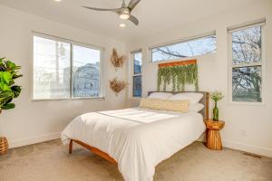 丹佛Modern Denver Vacation Rental with Rooftop Deck!的一间卧室配有一张带白色床单和窗户的床。