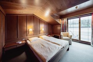 阿尔卑斯休斯山席赛阿尔姆广场酒店的卧室配有床、椅子和窗户。