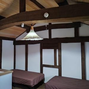 Tomivacation house WAKURA的客房设有两张床和光线充足的天花板。